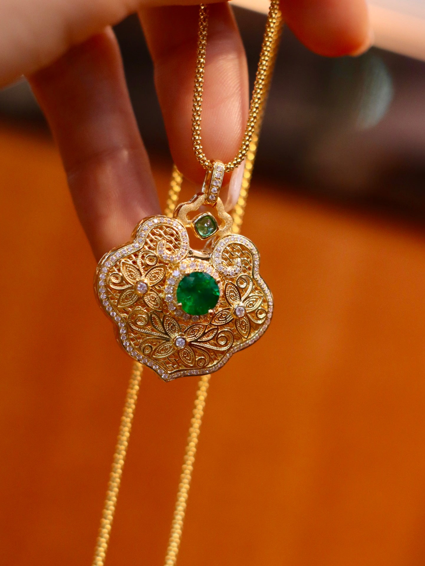 Exquisito colgante con candado de paz esmeralda y hoja de jade de rama dorada - Joyería Premium