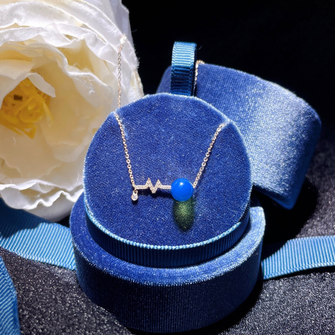 Wykwintny wisiorek z 18-karatowego złota z osadzonym niebieskim bursztynem dominikańskim - znaczące spotkanie w biżuterii