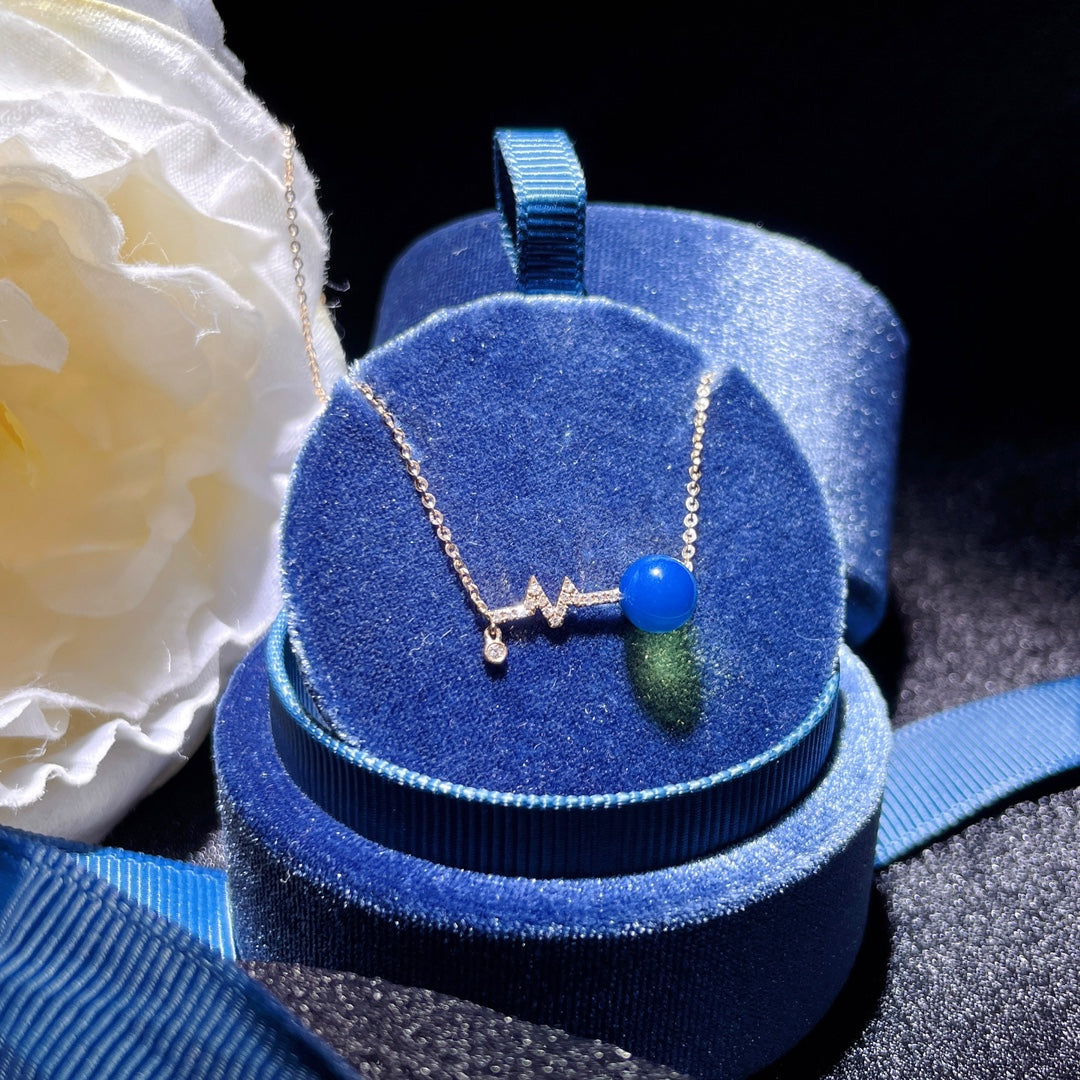 Wykwintny wisiorek z 18-karatowego złota z osadzonym niebieskim bursztynem dominikańskim - znaczące spotkanie w biżuterii