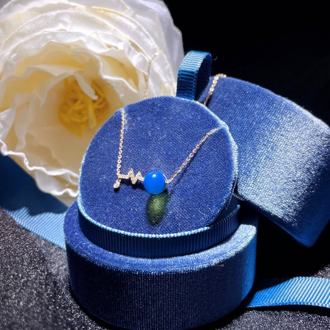 Wykwintny wisiorek z 18-karatowego złota z osadzonym niebieskim bursztynem dominikańskim - znaczące spotkanie w biżuterii