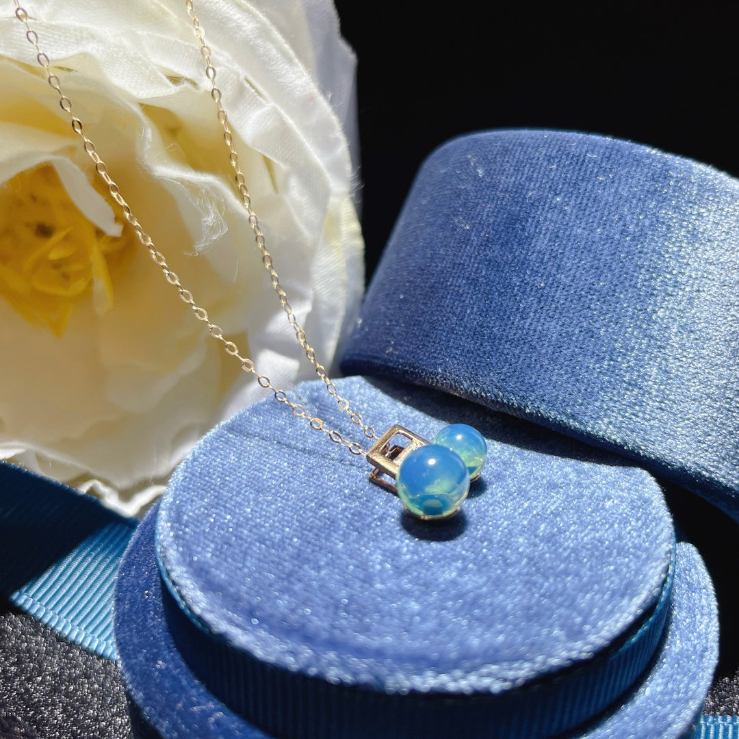 Eco otoñal de la primavera: Colgante de ámbar azul dominicano incrustado en oro de 18 quilates - Joyería Única